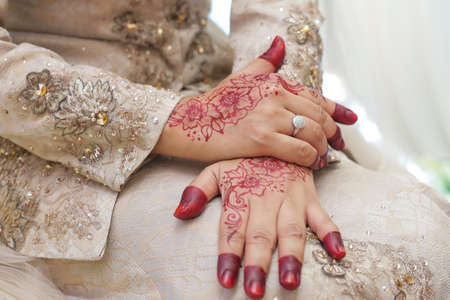 Bride's hand, image of mehendi henna pattern. Short manicure nails. Beautiful composition, fabric background banner. Round mandala abstract flowers, flowers lilac. Close up professional art photoの写真素材