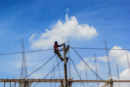 Electricity Authority on electricity post to repair a cableの写真素材
