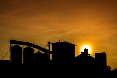Silhouette of rice mill with sunset sky.の写真素材