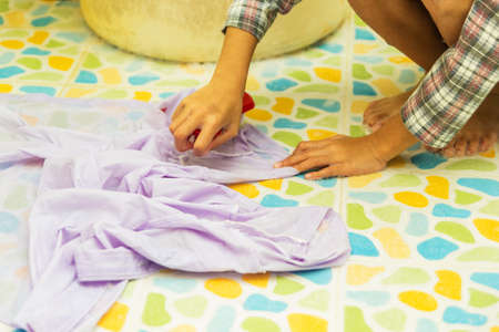 Close up shot child hand washing white shirt.の写真素材