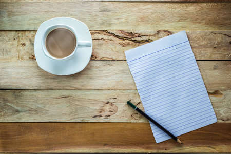 Top view shot Paper and pencil with hot coffee on wood tableの写真素材