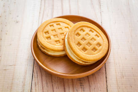 Two waffles in wood dish on wood tableの写真素材