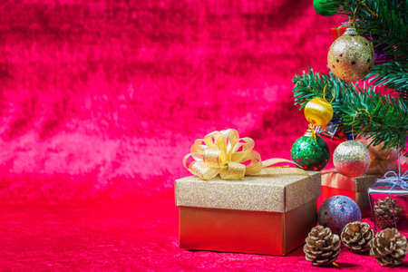 Gift and christmas ornaments with red backdropの写真素材