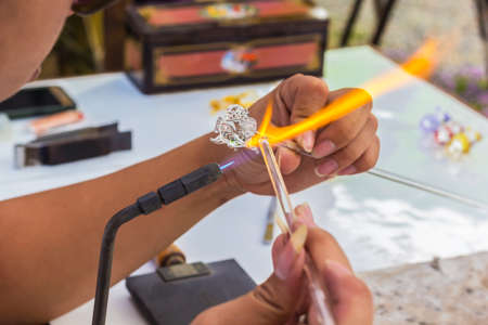 Close up shot hand of Glass blowing worker, Selective focus on glassの写真素材
