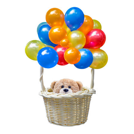 A photo of Teddy bear sitting in the basket of a colorful balloon tied to it on white isolate backgroundの写真素材