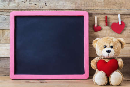 A photo of Teddy bear with heart sharp and black boardの写真素材