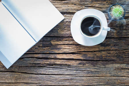 A photo of Coffee and book on wood tableの写真素材