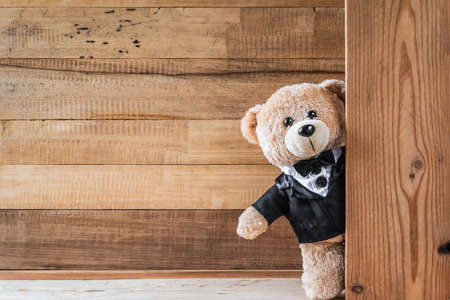 A photo of Cute teddy bear on old wood background with copy spaceの写真素材