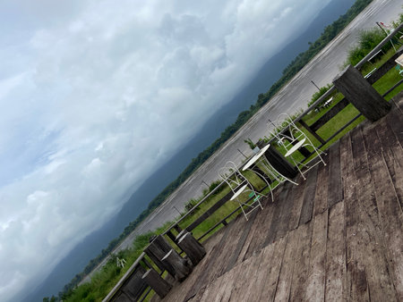 Wooden terrace with table and chair on the background of stormy skyの写真素材
