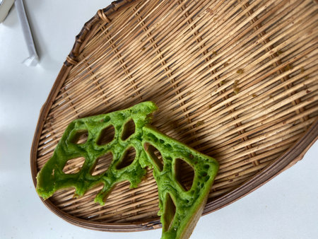 Green leaf of bitter gourd in bamboo basket on white backgroundの写真素材