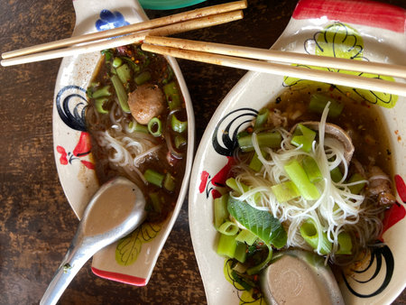 Vietnamese rice noodle soup with pork and vegetable on wooden tableの写真素材