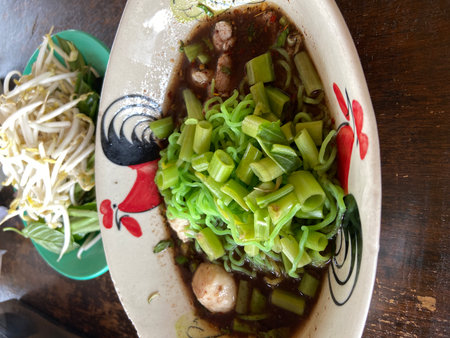 Rice vermicelli with meat and vegetables on wooden tableの写真素材