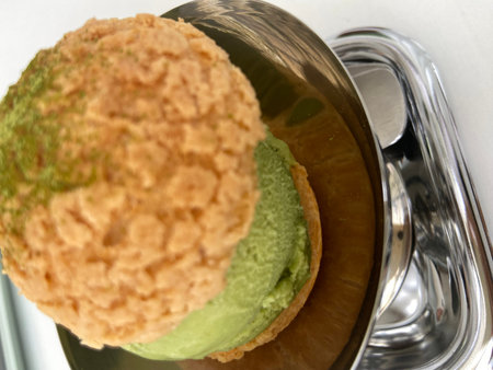 Green tea ice cream in glass bowl on white background, close up