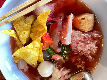 Sour soup with shrimp, bean sprouts and corn chips in bowl