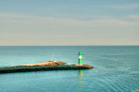 Green lighthouse with reflection of the green in the water, Germanyの写真素材
