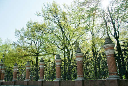 The ornate fence posts outside the Church of Our Spilled Blood in St  Petersburg, Russia    The black wrought iron contrasts the bright green of spring foilageの写真素材