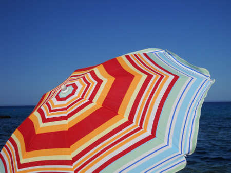     Colorful umbrella on the beach end the mediterranean sea on the background      の写真素材