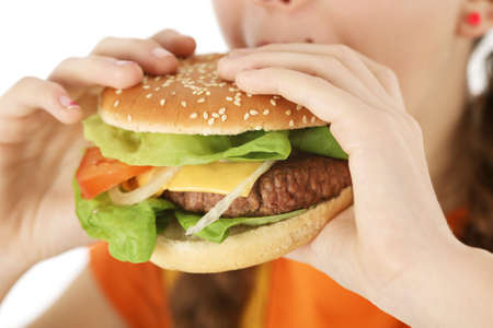closeup girl eating hamburger with both handsの写真素材