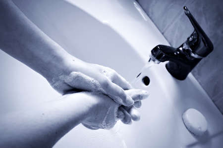 Sanitary disinfection protocol. Woman washing her hands with antiseptic soap and hot water to...