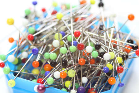 Multicolored dressmaker's needle push pins box on white backgroundの写真素材