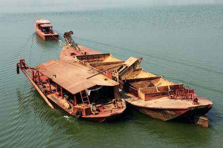 Tugboat pulling  barge of sandの写真素材