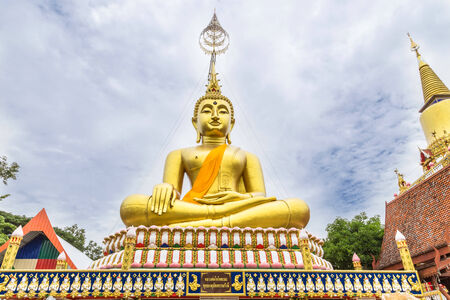 big white buddha statue sitting on thai templeの写真素材