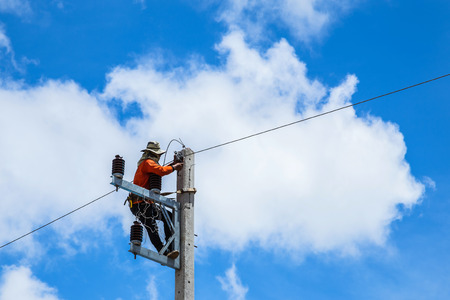 electrician repairing wire of the power line on electric power poleの写真素材