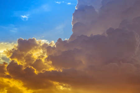 abstract yellow dark clouds on blue sky in sunsetの写真素材