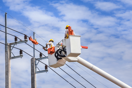 electrician  repairing wire of the power line on basket hydraulic lifting platform vehicle