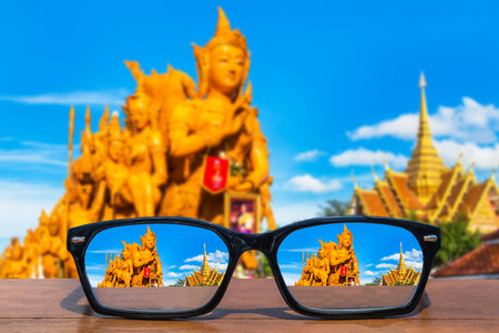 eyeglasses on wooden table front of Thai candle festival  at Ubon Ratchathani, Thailandの写真素材
