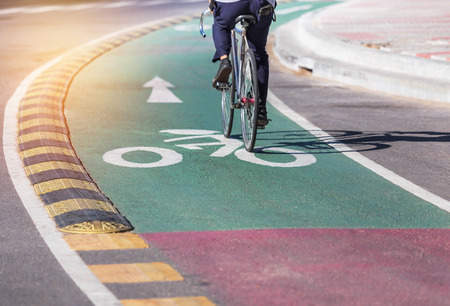 white bicycle lane sign and arrow on green asphalt road