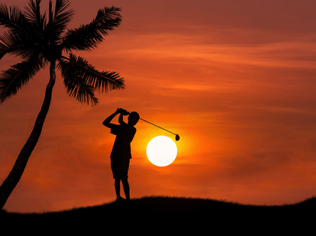 silhouette golfer hitting golf shot on sunset with palm treesの写真素材