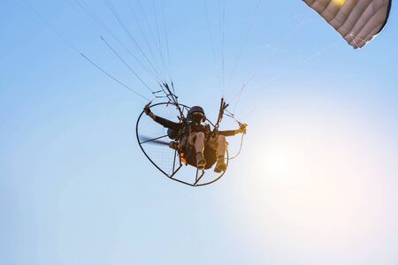 silhouette paraglider flying  with paramotor on sunsetのeditorial素材