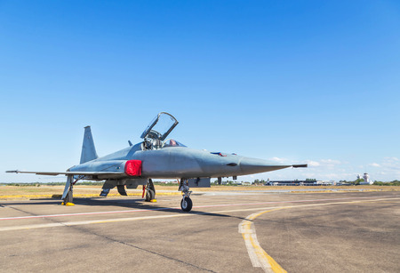 military fighter jet aircraft parked on runway in airforce on blue sky background