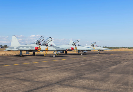 military fighter jet aircrafts parked on runway  in airforce on blue sky background