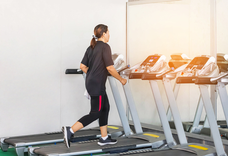 sporty woman exercise running on treadmills in modern fitness room center gym