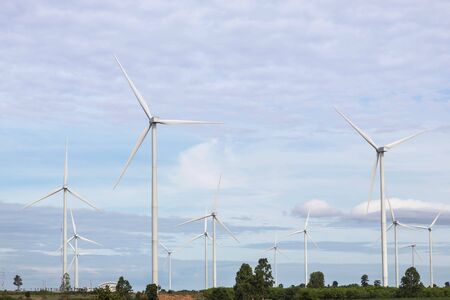 Row of white wind turbines generating electricity in wind power station under blue sky backgroundの写真素材