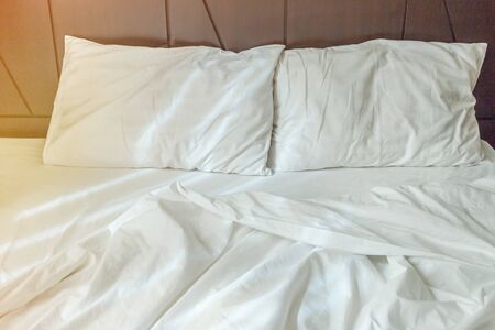 Two white pillows with white bedding sheet on empty bed in bedroom for rest and relax in the morning