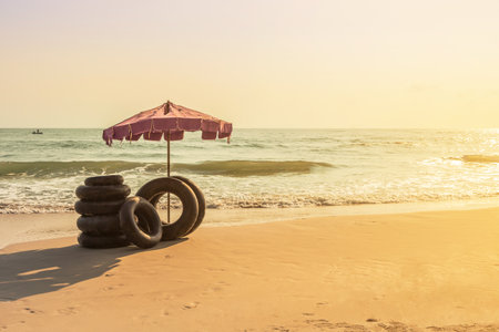 beach umbrella with ring lifebuoys on tropical sandy beach in the morning, summer holidays concept.の写真素材