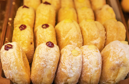 Close up row of sweet golden donuts with jam for breakfastの写真素材