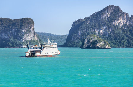 Large ferryboat carrying passengers and cars crossing in blue seaの写真素材