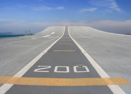 Tarmac runway track on deck of aircraft carrier with blue skyの写真素材