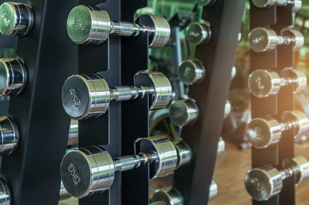 Close up row of metal dumb bells for bodybuilding muscle growth on rack in sport fitness center ,healthy lifestyle concept .の写真素材