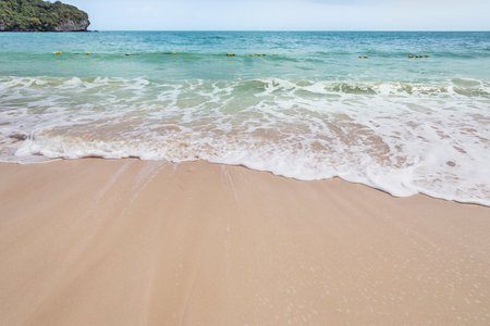white soft wave rolling splash on the empty tropical beachの写真素材