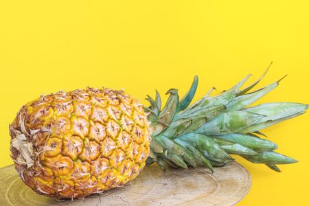 Summer composition. Pineapple on a yellow background.