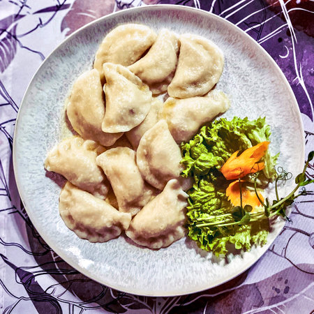 boiled dumplings on a plate with a salad on the tableの写真素材