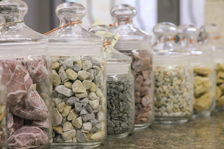 Different natural small pebbles in glass jarsの写真素材