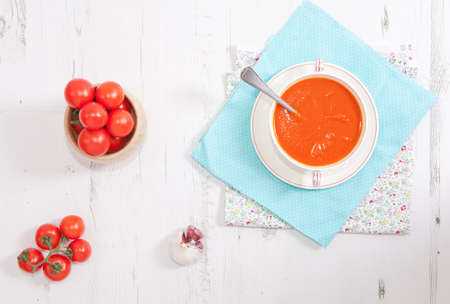 Tomato soup on the white wooden table, top viewの写真素材