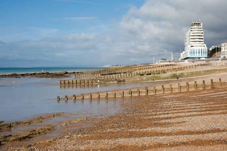 Hastings sea front in a low tide, East Sussex, England, view to the west of the pier, selective focus on the nearest sea groinの写真素材