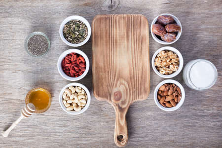 Grain free oat free paleo granola ingredients: mixed nuts, seeds, goji berries, chia, honey and coconut oil, selective focusの写真素材